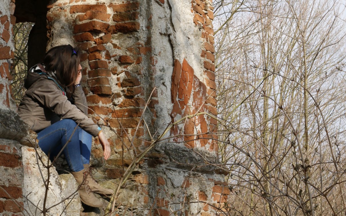 mladá žena sedící v ruinách kostela a hledící do dáli / foto Michal Němeček